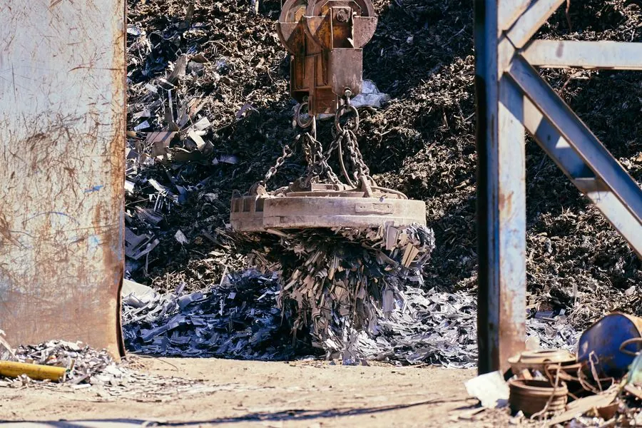 Crane lifting scrap metal at a recycling yard